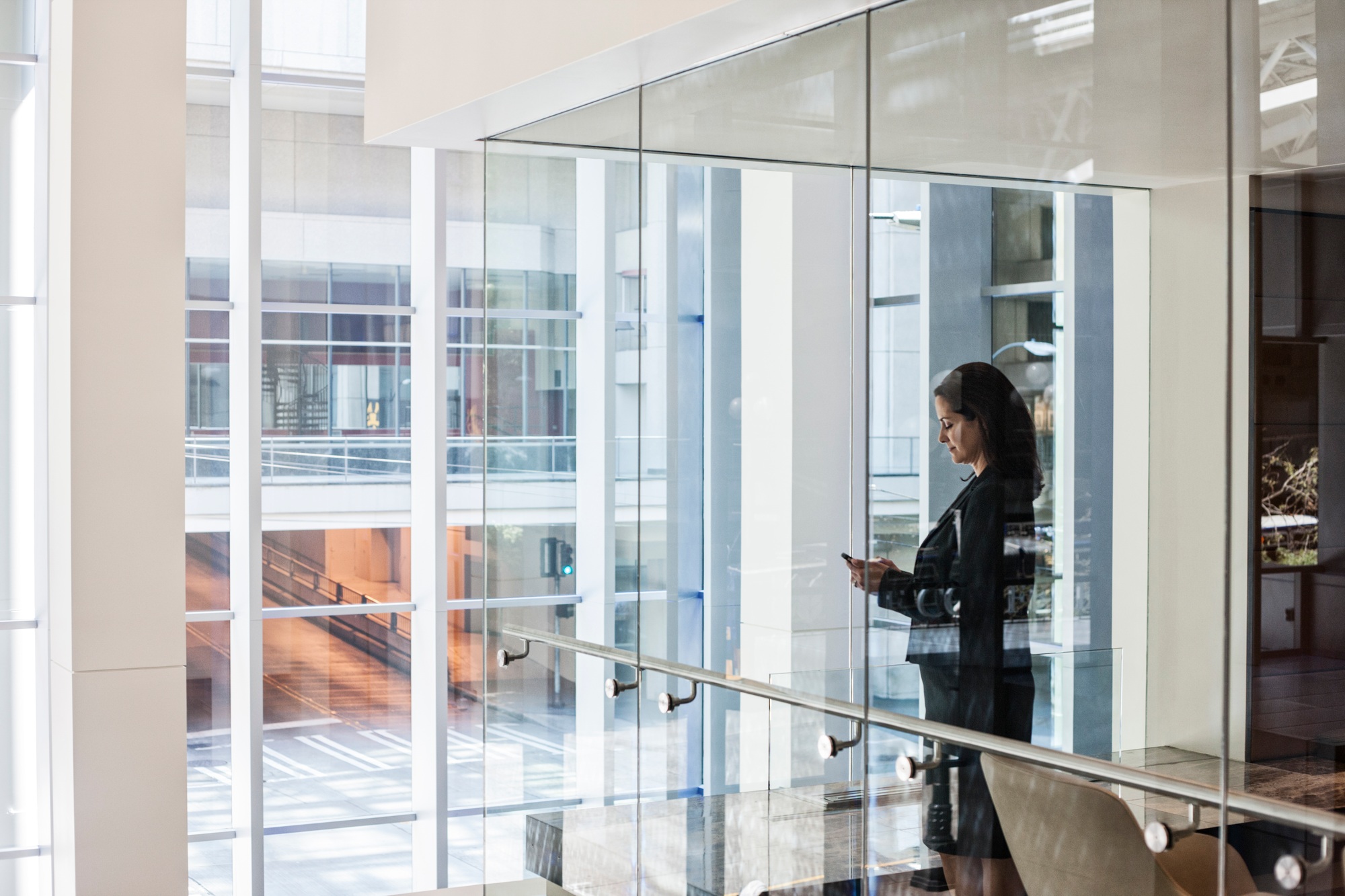 businesswoman standing in a conference room window in a large business center